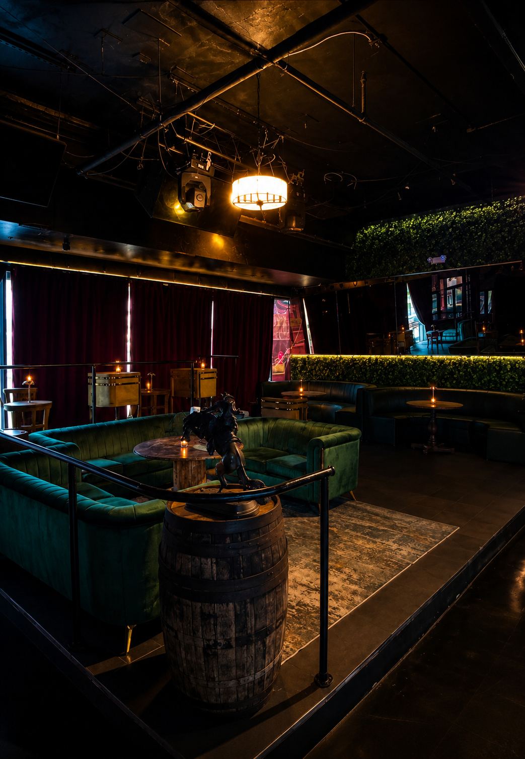 The elevated stage section with green velvet sofas